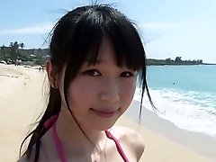 Slender Chinese dame Tsukasa Arai walks on a sandy beach under the sun