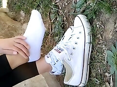 Chinese damsel sprains foot in white ankle socks and black stretch pants