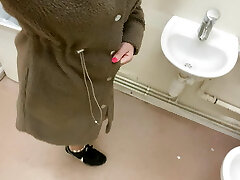 Fashionable pisses in the sink in the disabled public toilet