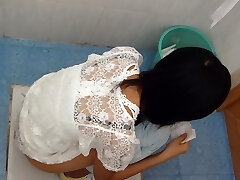 Asian brunette pissing in the public toilet