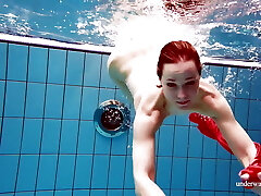 Cute babe in red sexy open sundress swimming