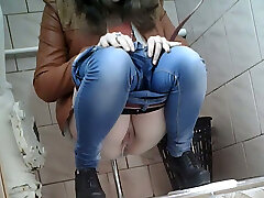 Slender girl in very tight blue denim filmed in the restroom room
