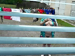Bare in public. Neighbor saw pregnant neighbor in window who was drying clothes in yard without boulder-holder and panties. Nudist