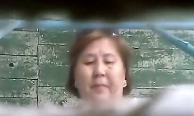 Mature Asian damsel in the shabby toilet room filmed on covert cam