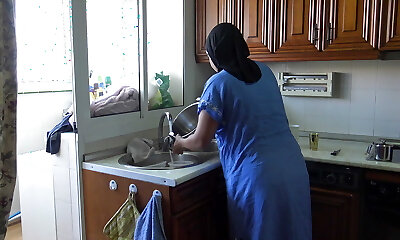 une femme égyptienne enceinte se fait cramponner en faisant la vaisselle