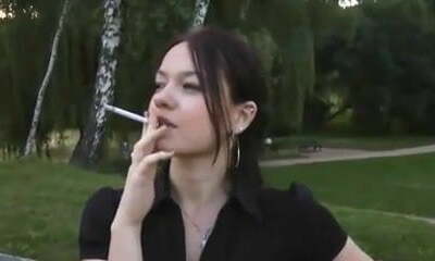 ragazza di fumare sulla panchina del parco