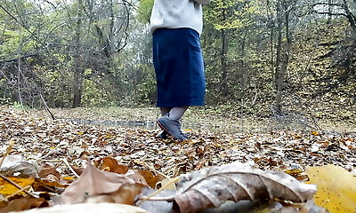 Curvy MILF in a lengthy mini-skirt pissing in the autumn park