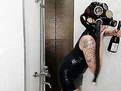Backstage from the Halloween shoot. Mistress in a gas mask and latex is doused with wine