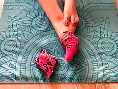 Gloria Gimson in pink socks caresses her gesille plamer on a yoga mat