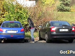 Raven haired filthy gal makes pees between two cars outdoors
