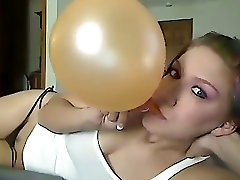 Domino Blowing Up a Pearly Orange Balloon