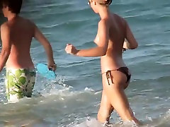 Topless girl playing on the beach and getting voyeured