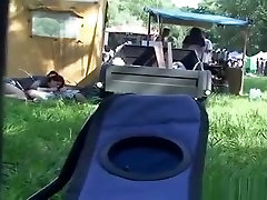 Drunk girl having small wife laugh with friends with a boy under a tent