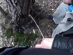 my boyfriend holding my pissing cock outdoor in the woods