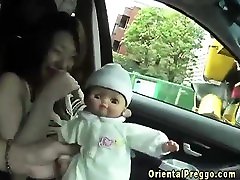 enceinte asiatique sein des flux de poupée en voiture