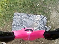 Hanging upside down Lucy Latex has to suck latex cock outdoors