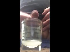 rubbing one out with some cumshots in a measuring glass.