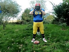 footballpup pawing off outdoors - dumping load on helmet