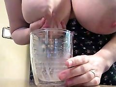 Big pregnant versnobe filling cup with milk