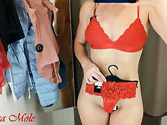 A girl with a perfect figure with small breasts in the fitting room tries on different mon non lingerie, a selection.