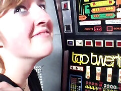 A girl in a casino plays the slots and sucks a guys cock