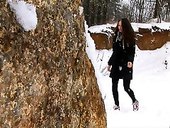 Brunette huma gomal university scendel young chick walks in the winter forest and pisses behind the rock