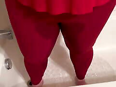 गर्म लड़की तंग लाल योग पैंट में पेशाब करने के लिए बेताब