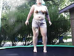fette tätowierte milf springt und strippt auf einem trampolin