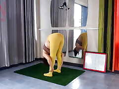 رجینا نوار. یوگا در جوراب شلواری زرد انجام یوگا در ورزشگاه. دختری بدون dady arabic در حال انجام یوگا است. یک ورزشکار در یک پ تمرین می کند
