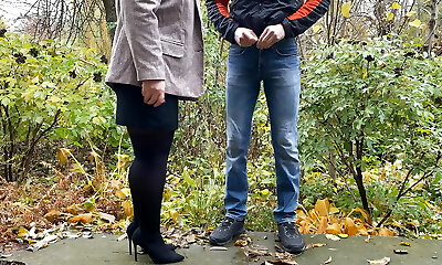 Steamy milf in pantyhose and skirt holding guy's man-meat outdoors while pissing