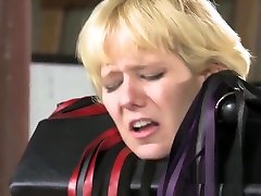 Blonde bound in standing frame flogged
